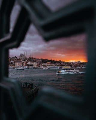 İlkin Karacan Karakuş sony A7RM3 de zon die ondergaat boven de bosporus, gezien door een stervormige opening in een balustrade